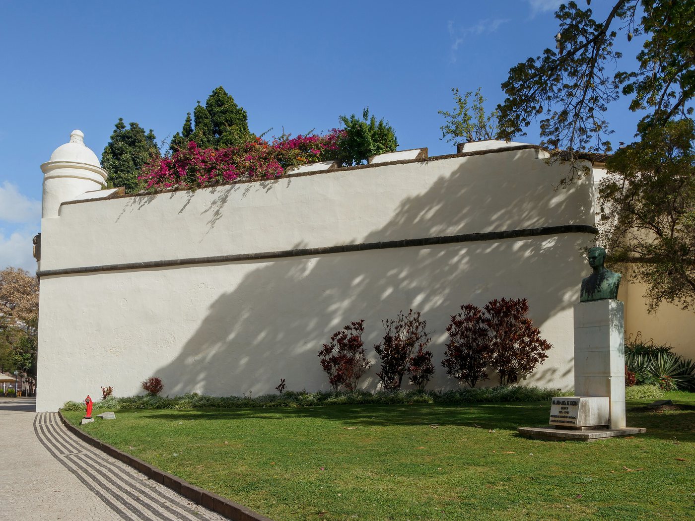 Muralha rebocada e cantaria do Palácio de São Lourenço, no Funchal, com calçada de basalto em primeiro plano